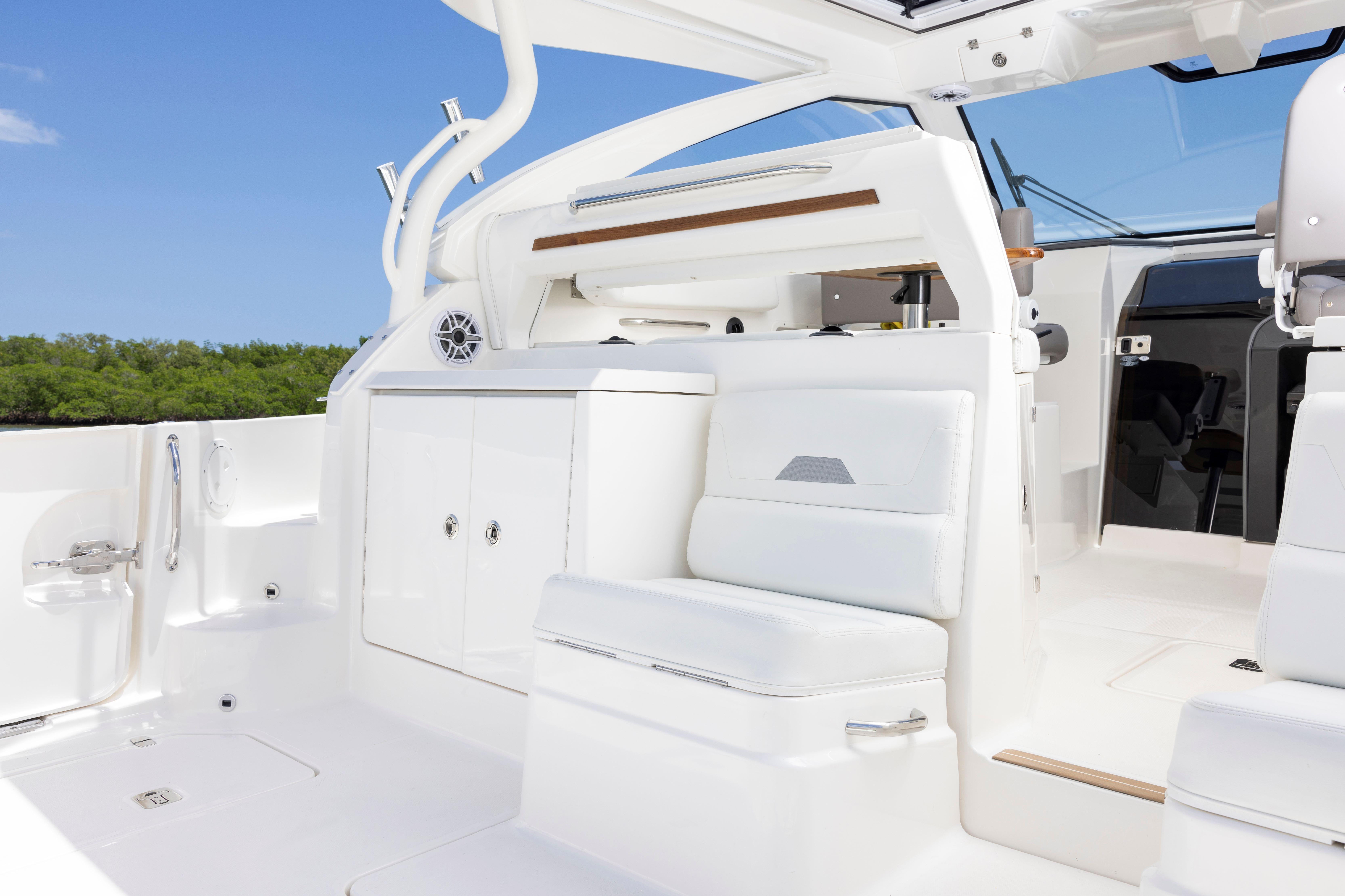 Luxurious interior of 2026 Pursuit OS 405 Offshore boat with white seating and cabinetry.