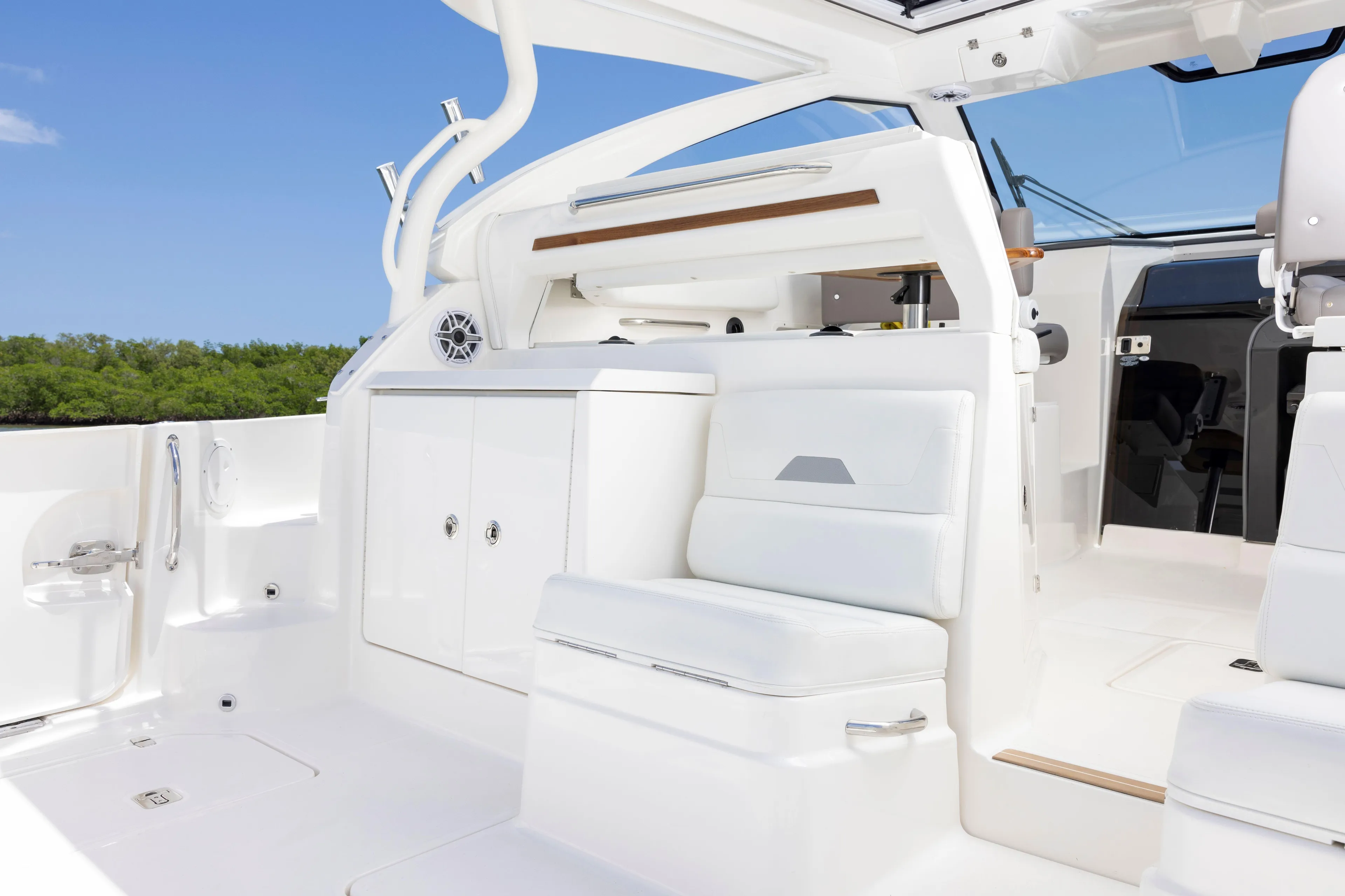 Luxurious interior of 2026 Pursuit OS 405 Offshore boat with white seating and cabinetry.