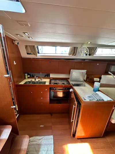 Yes My Dear Yacht Photos Pics Interior of 2012 Beneteau Oceanis 41 yacht, featuring a modern kitchen with wood cabinetry.