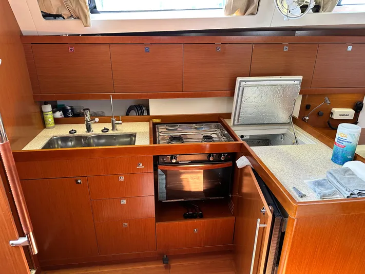 Yes My Dear Yacht Photos Pics Galley kitchen in 2012 Beneteau Oceanis 41 sailboat with wood cabinetry and stainless steel sink.