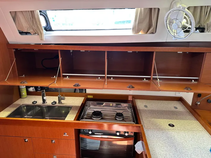 Yes My Dear Yacht Photos Pics Interior of 2012 Beneteau Oceanis 41 yacht kitchen with wooden cabinets and stainless steel appliances.