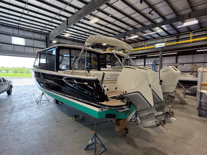 Coco Yacht Photos Pics 2022 MJM 3 boat in a warehouse, featuring dual outboard motors.