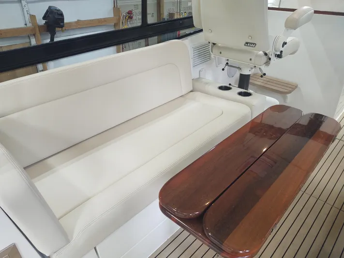 Coco Yacht Photos Pics Luxury seating area on 2022 MJM 3z boat with wooden table.