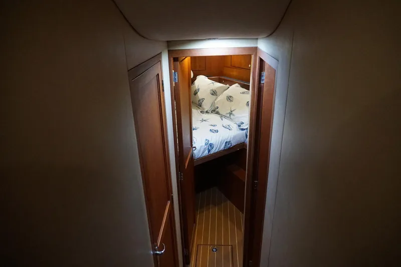 Sea Striker Yacht Photos Pics Cozy cabin interior of 2005 Mirage Yachts 40 Convertible with wooden doors and nautical bedding.