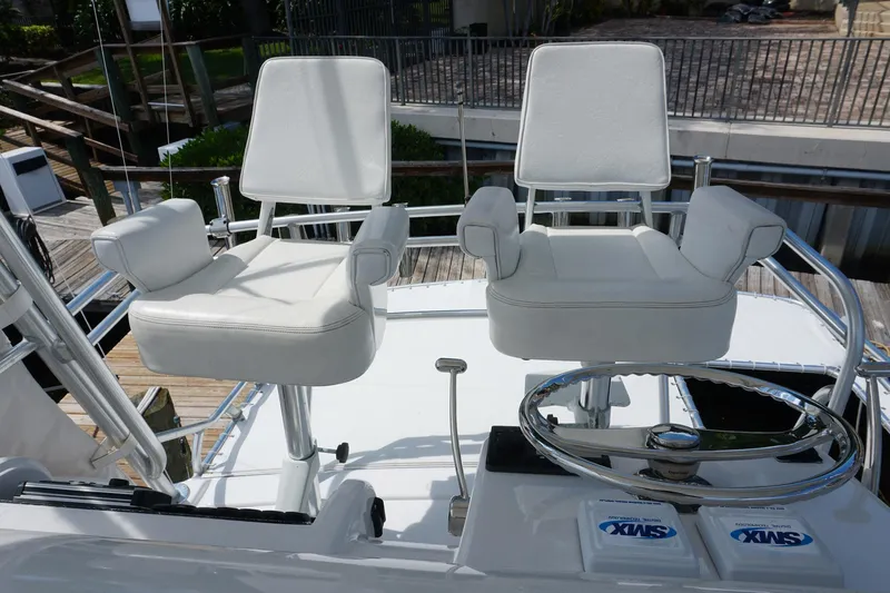 Sea Striker Yacht Photos Pics Captain's chairs on 2005 Mirage Yachts 40 Convertible, featuring white upholstery and helm controls.