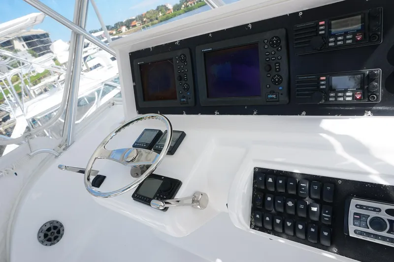 Sea Striker Yacht Photos Pics Control panel of 2005 Mirage Yachts 40 Convertible with navigation equipment and steering wheel.