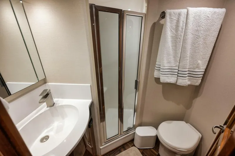 Triple Trouble Yacht Photos Pics Bathroom interior of 2014 Viking 62 Convertible yacht with shower, sink, and toilet.