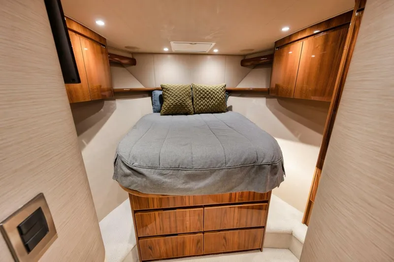Triple Trouble Yacht Photos Pics Luxurious cabin interior of 2014 Viking 62 Convertible yacht with wooden cabinetry and cozy bedding.