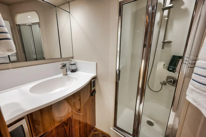 Triple Trouble Yacht Photos Pics Luxurious bathroom in 2014 Viking 62 Convertible yacht with modern shower and sleek vanity.