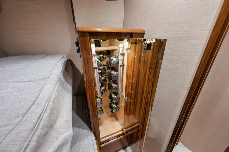 Triple Trouble Yacht Photos Pics Fishing rod storage in 2014 Viking 62 Convertible yacht cabin, featuring wooden cabinetry.