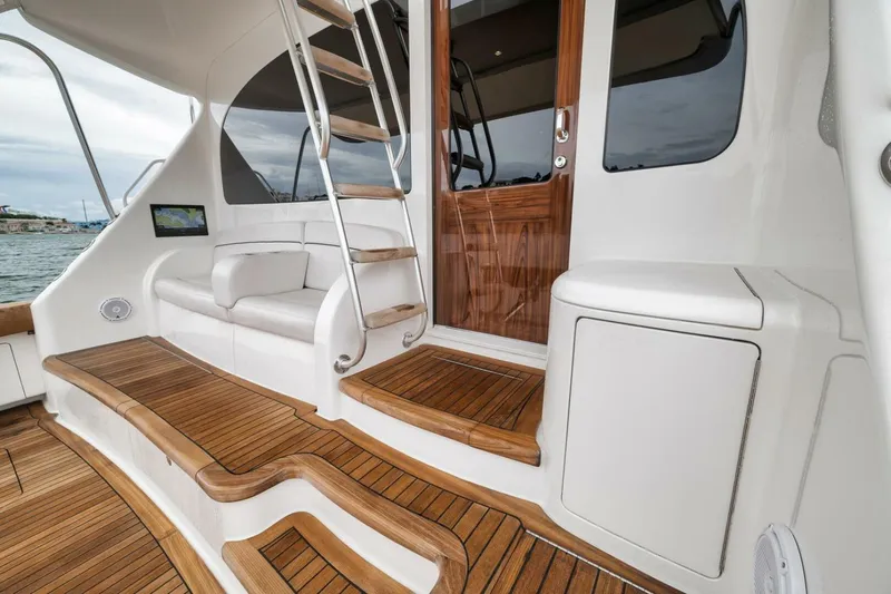 Triple Trouble Yacht Photos Pics Luxurious 2014 Viking 62 Convertible yacht interior with wooden steps and seating.