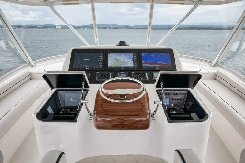 Triple Trouble Yacht Photos Pics 2014 Viking 62 Convertible yacht helm with navigation screens and controls on open water.