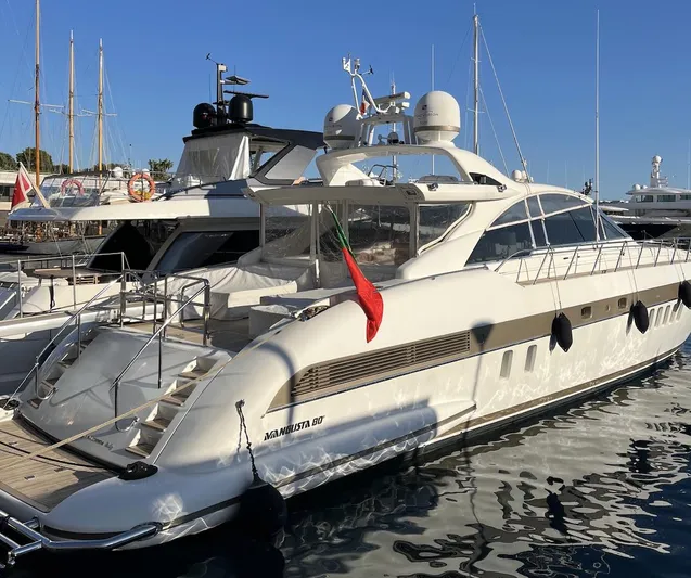  Yacht Photos Pics Luxury 2006 Mangusta 80 yacht docked in a marina, showcasing sleek design and elegance.