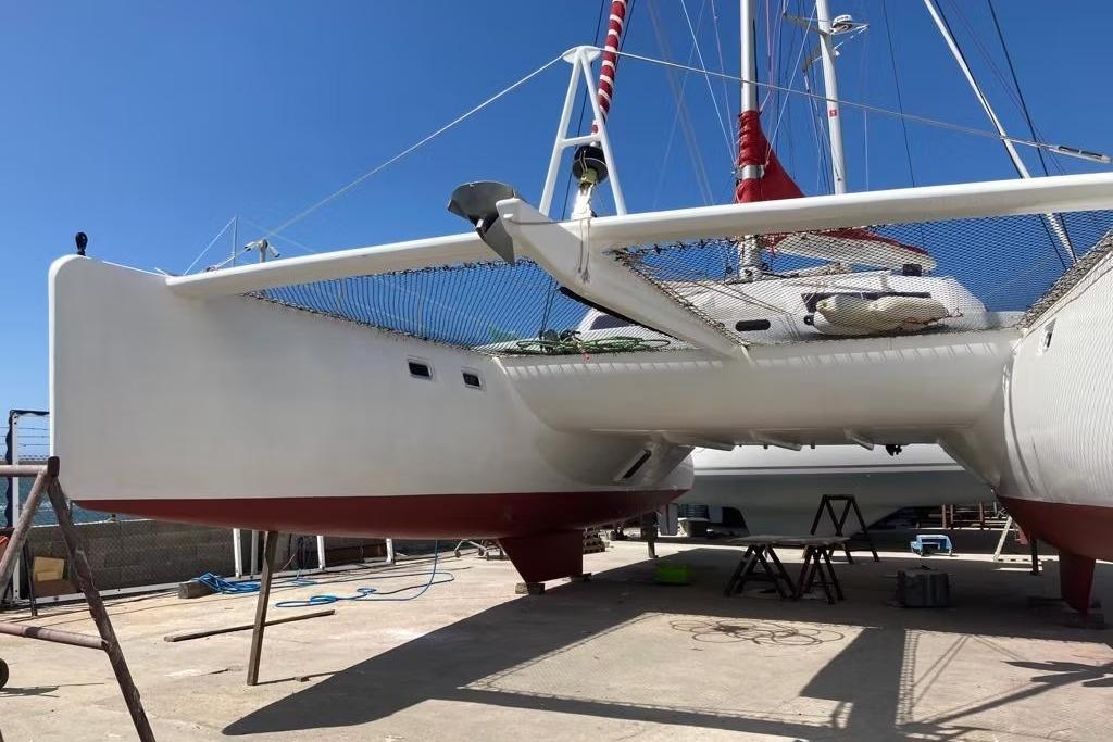 Catamaran Looping 50, 2017 model, docked for maintenance under clear blue sky.