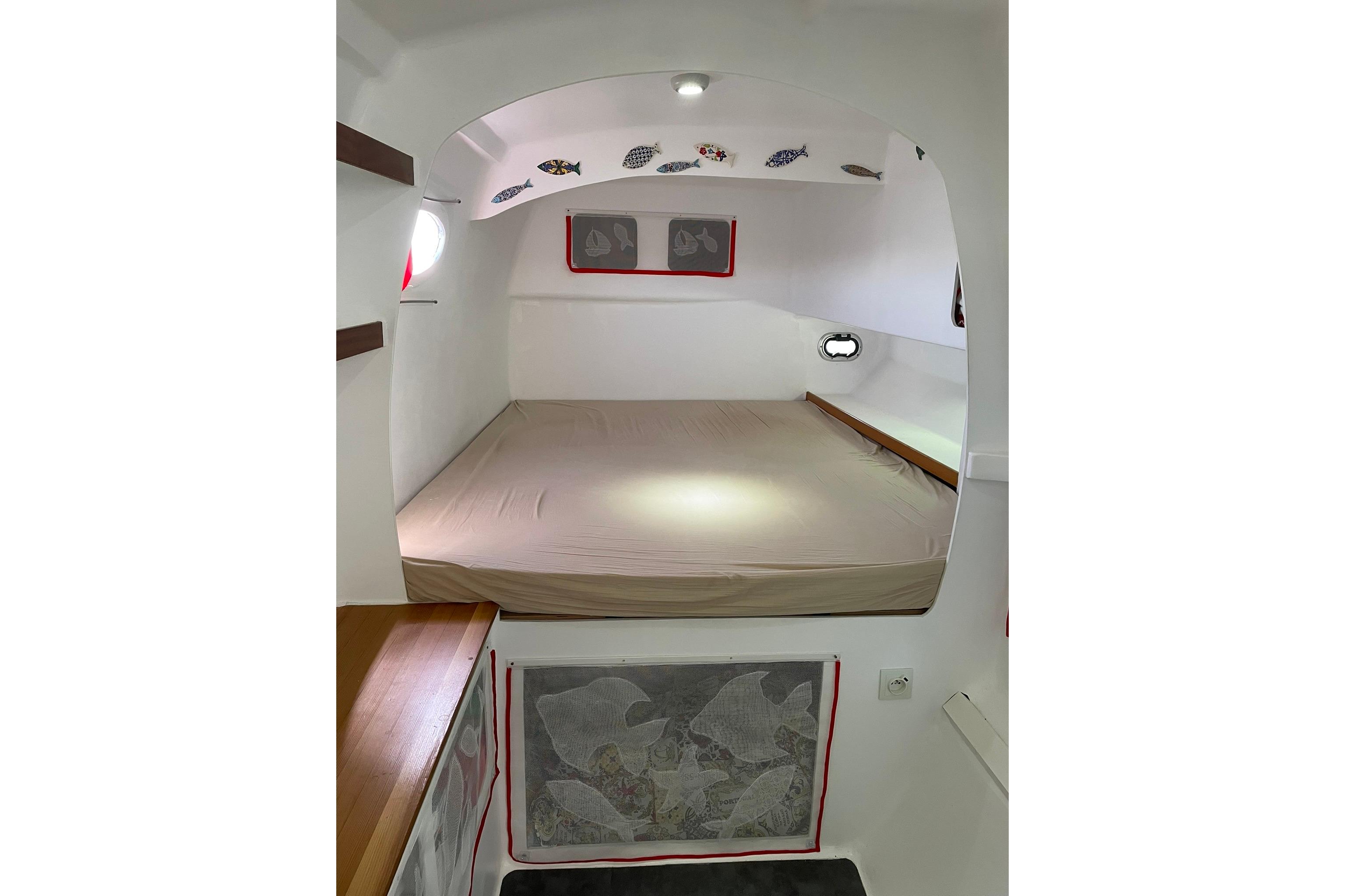 Cozy cabin interior of 2017 Looping 50 catamaran with bed and nautical decor.