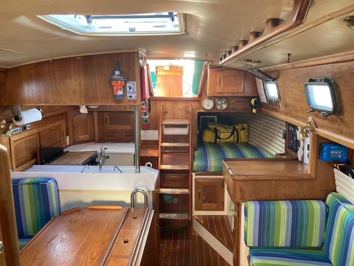 Hero Yacht Photos Pics Interior of 1992 Pacific Seacraft 37 Cutter sailboat with wood finish and striped seating.