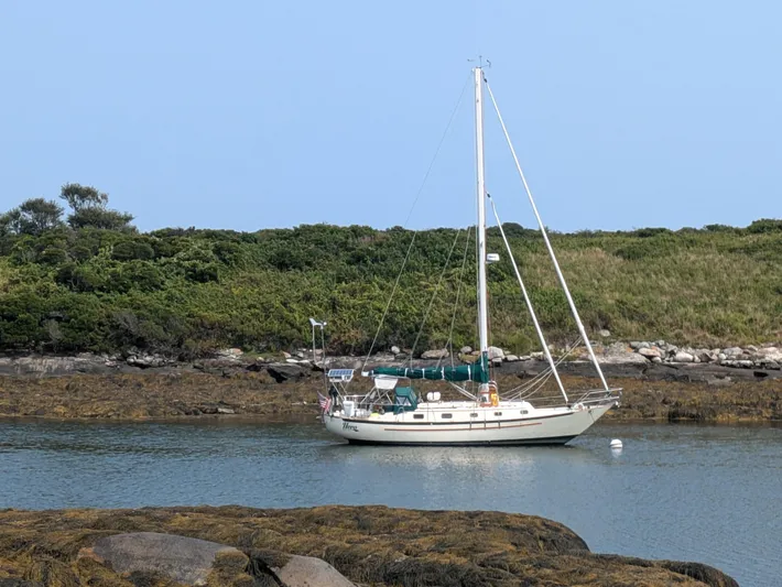Hero Yacht Photos Pics 1992 Pacific Seacraft 37 Cutter sailboat anchored in a serene coastal inlet.