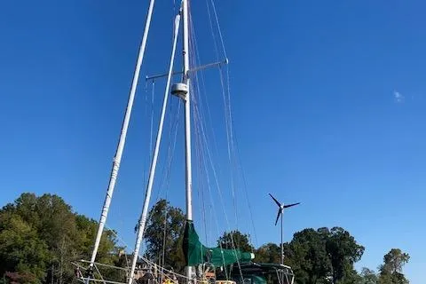 Hero Yacht Photos Pics 1992 Pacific Seacraft 37 Cutter sailboat with green cover, docked under clear blue sky.