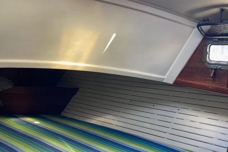 Hero Yacht Photos Pics Interior of 1992 Pacific Seacraft 37 Cutter with striped bedding and wooden paneling.