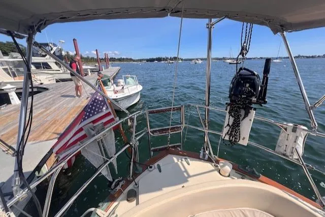 Hero Yacht Photos Pics 1992 Pacific Seacraft 37 Cutter docked, with American flag, overlooking calm marina waters.