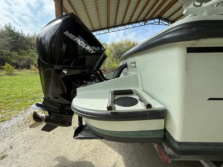  Yacht Photos Pics 2004 Boston Whaler Guardian 27 with Mercury outboard engine under a metal canopy.