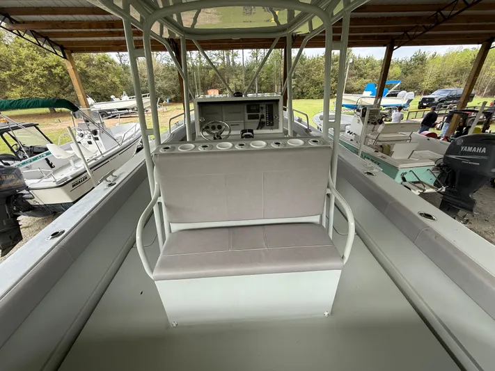  Yacht Photos Pics 2004 Boston Whaler Guardian 27 boat interior with seating and control panel under a canopy.