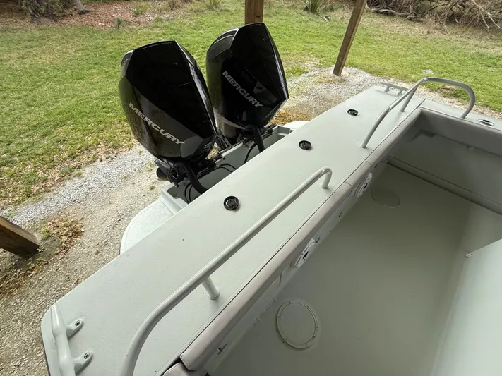  Yacht Photos Pics 2004 Boston Whaler Guardian 27 with dual Mercury outboard engines, docked on grassy area.