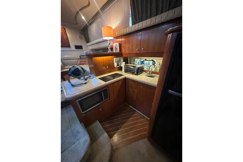 Busy Living Yacht Photos Pics 2005 Cruisers Yachts 375 Motoryacht interior kitchen with wooden cabinets and modern appliances.