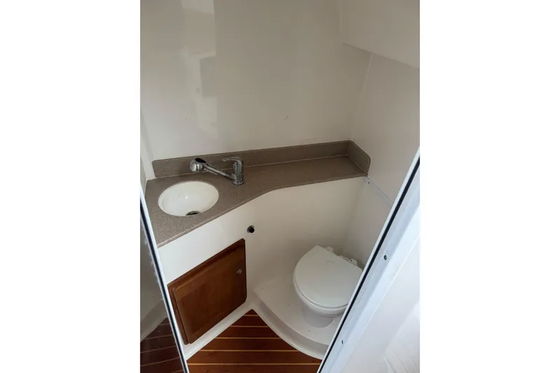  Yacht Photos Pics 2008 Contender 36 Fisharound boat bathroom with sink, toilet, and wooden cabinet.