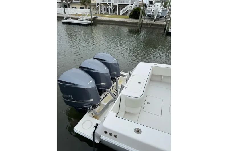  Yacht Photos Pics 2008 Contender 36 Fisharound with triple Yamaha outboard engines docked by the water.