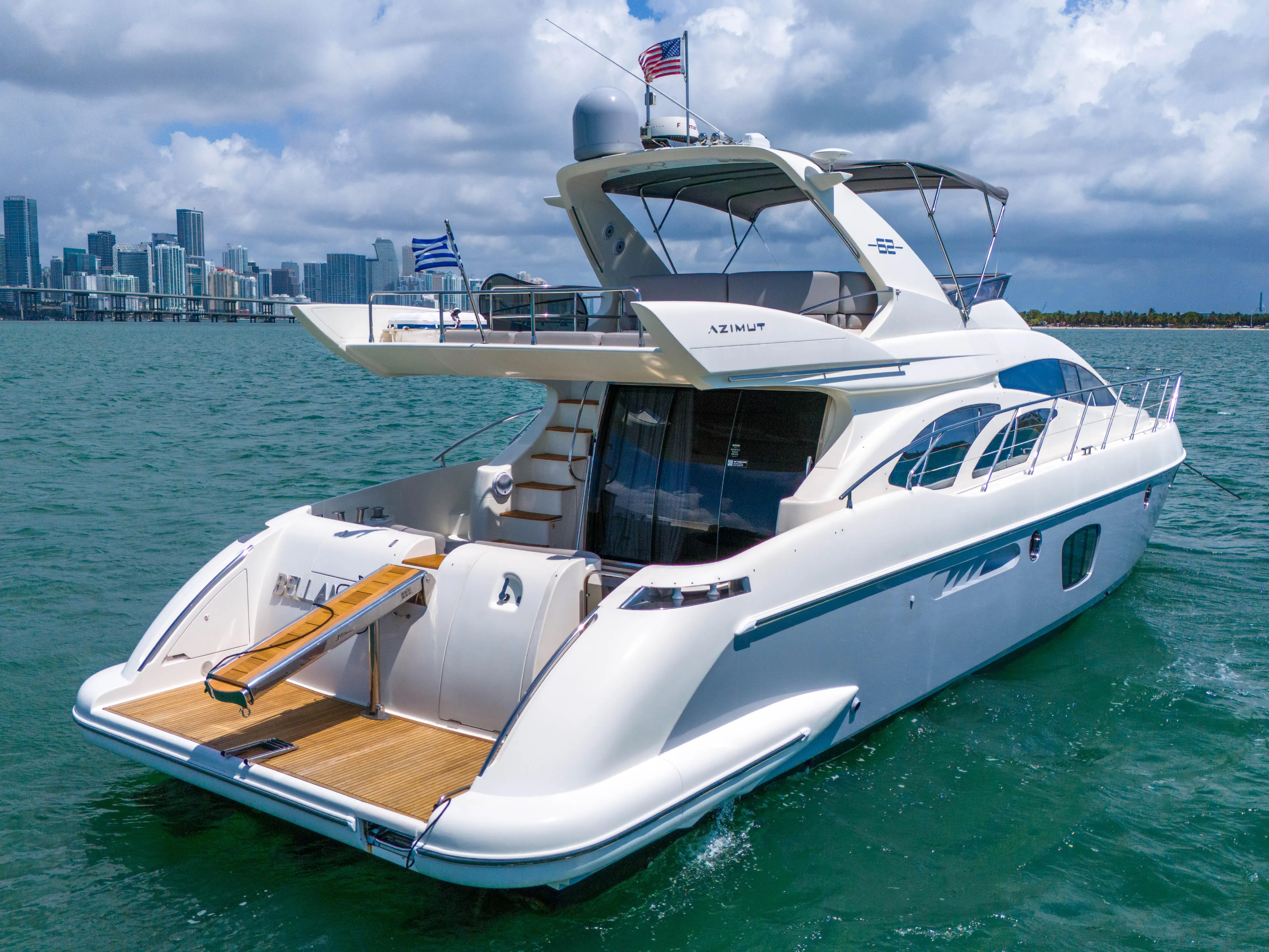 Bellami Too Yacht Photos Pics 2008 Azimut 62E yacht cruising on turquoise waters under a partly cloudy sky.