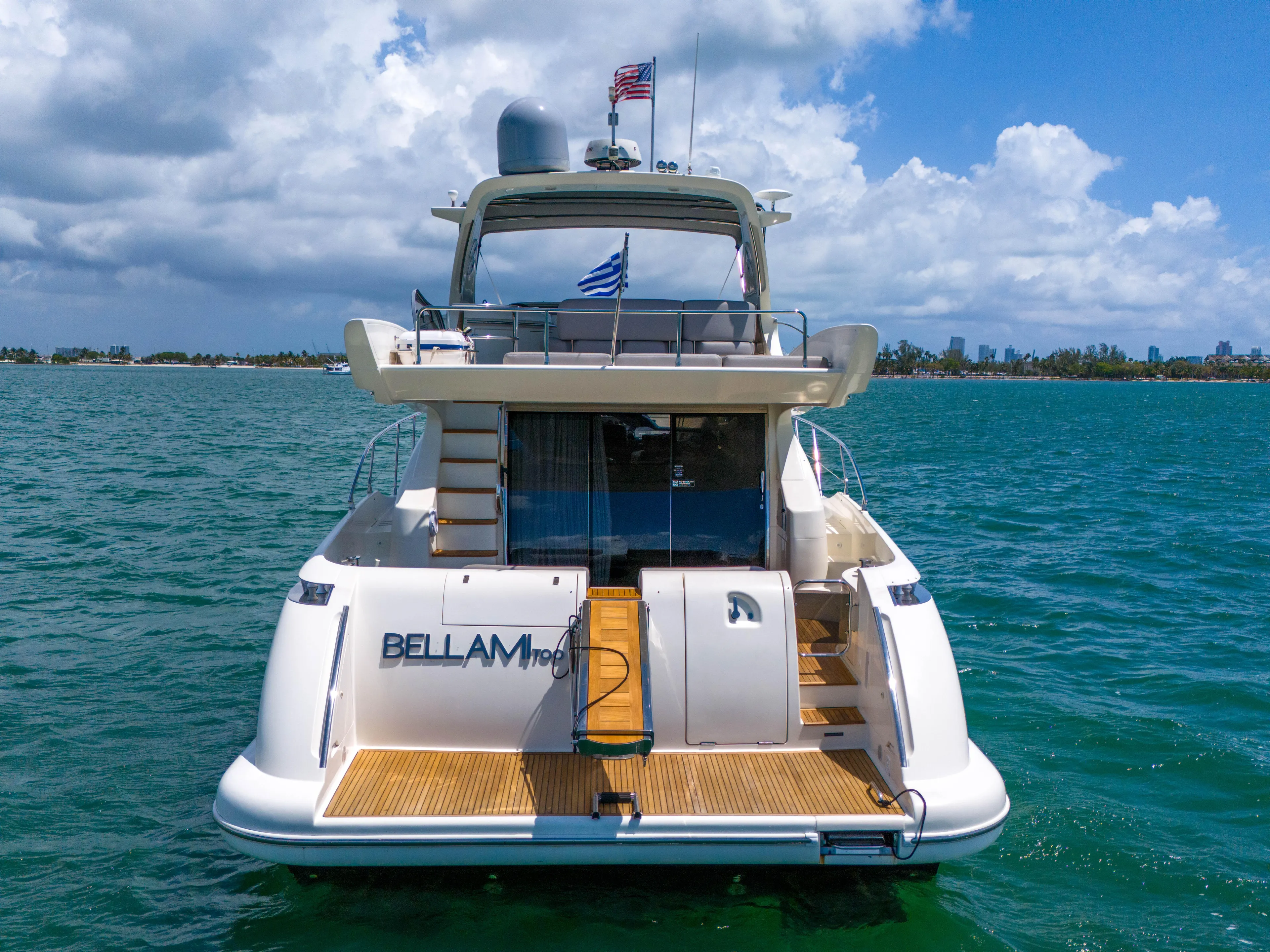 Bellami Too Yacht Photos Pics Azimut 62E 2008 yacht on water, rear view, with flags and clear sky.