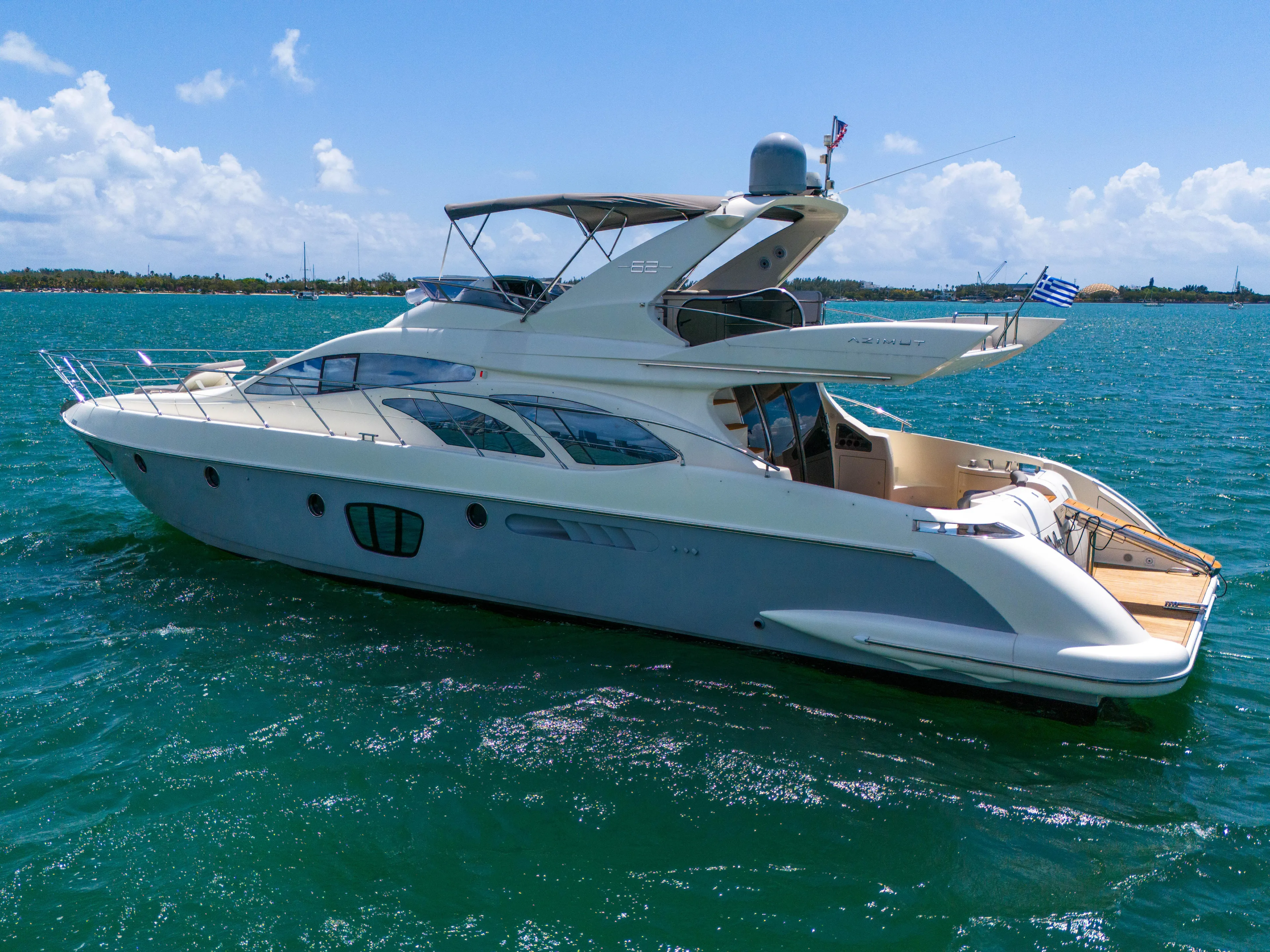 Bellami Too Yacht Photos Pics 2008 Azimut 62E yacht cruising on clear blue waters under a sunny sky.