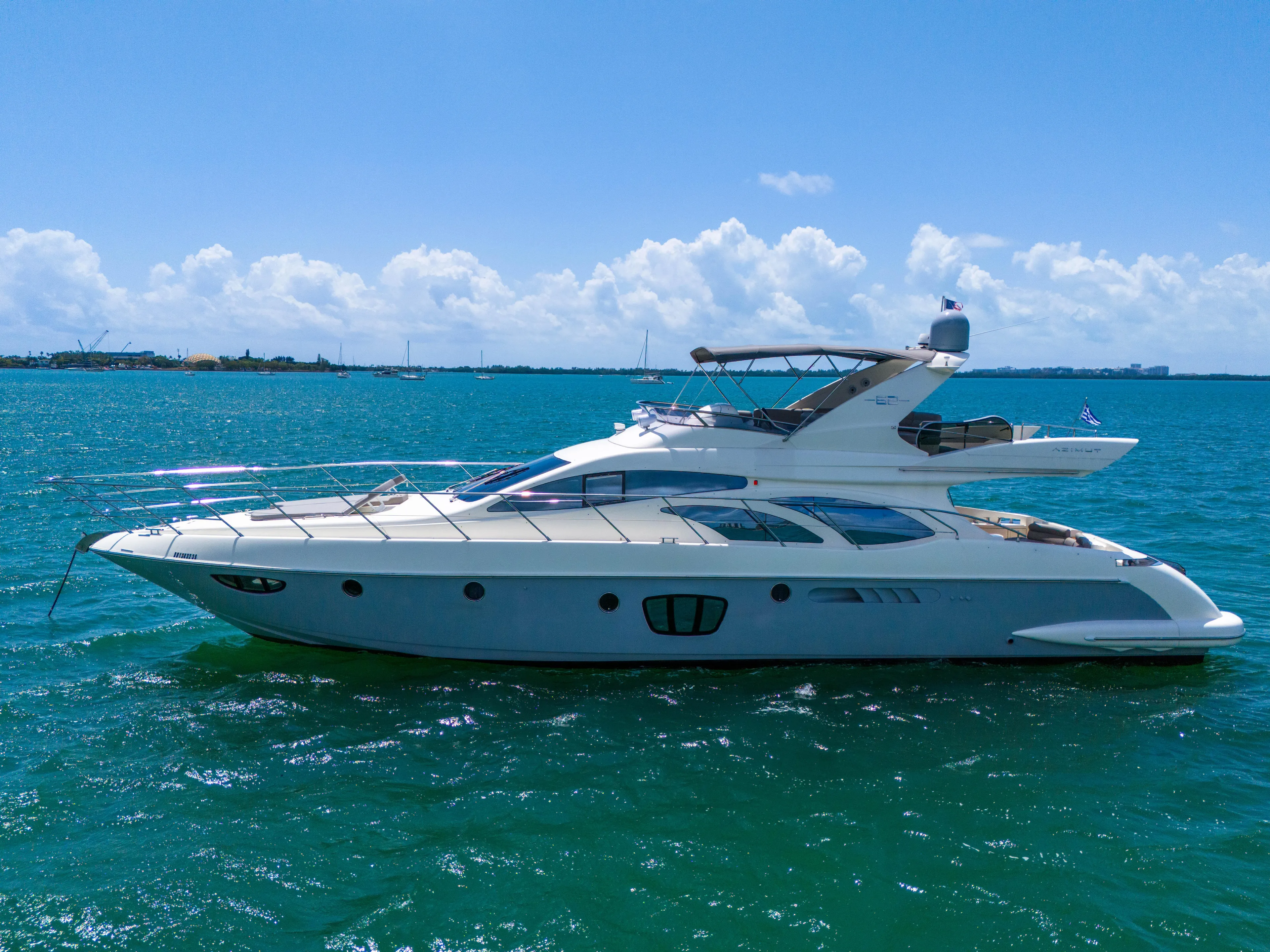 Bellami Too Yacht Photos Pics 2008 Azimut 62E yacht cruising on clear blue waters under a sunny sky.