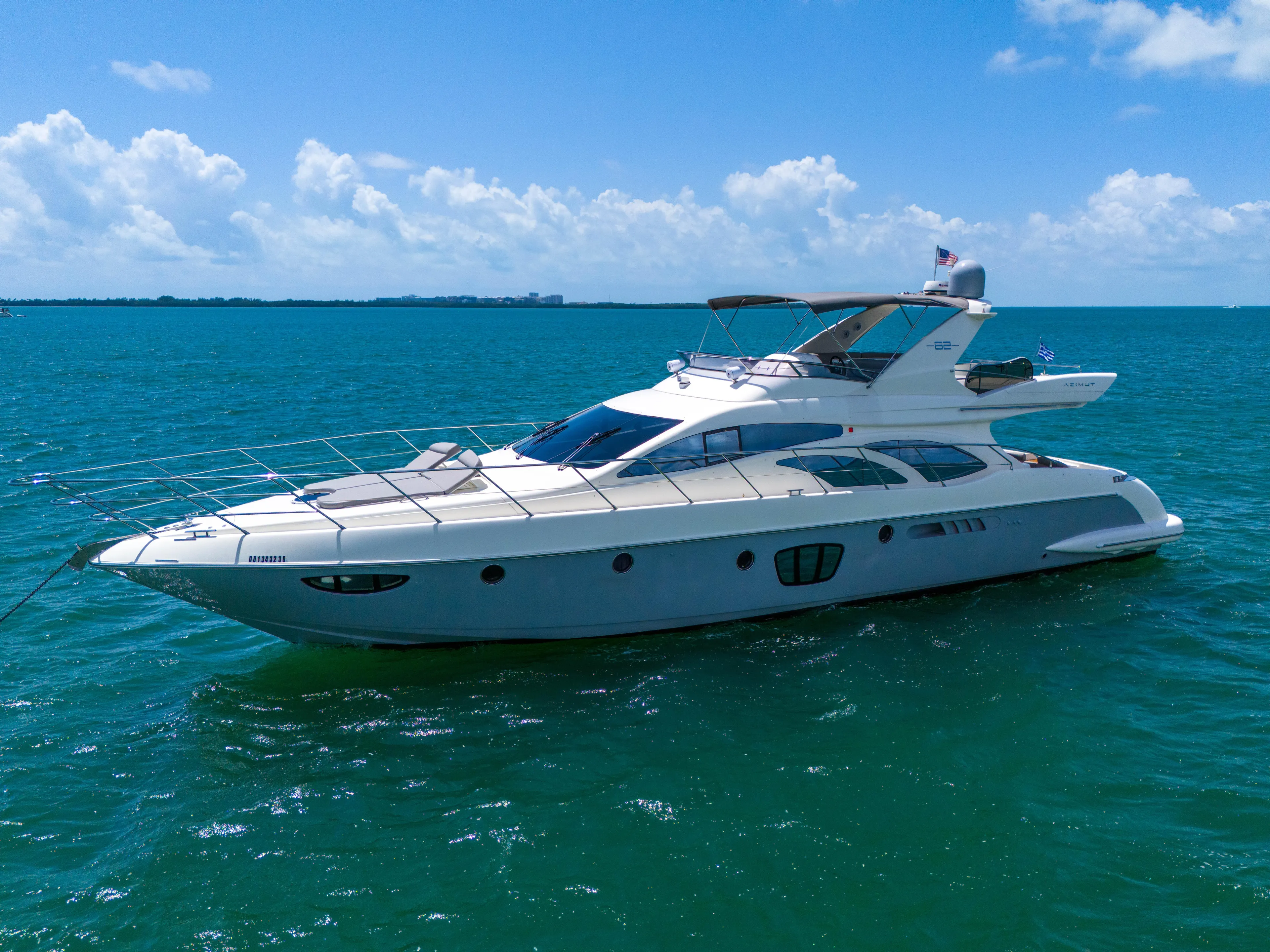 Bellami Too Yacht Photos Pics 2008 Azimut 62E yacht cruising on clear blue waters under a sunny sky.