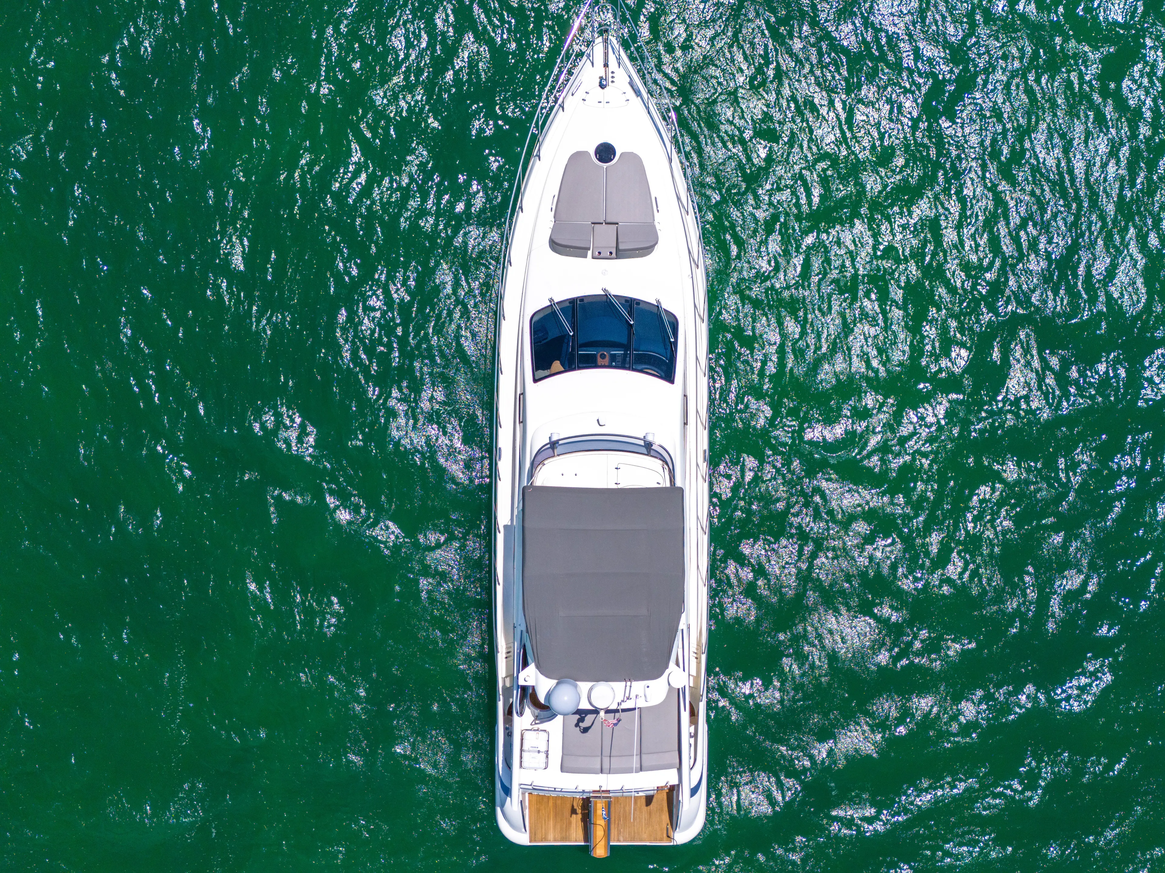 Bellami Too Yacht Photos Pics Aerial view of 2008 Azimut 62E yacht on vibrant green water.