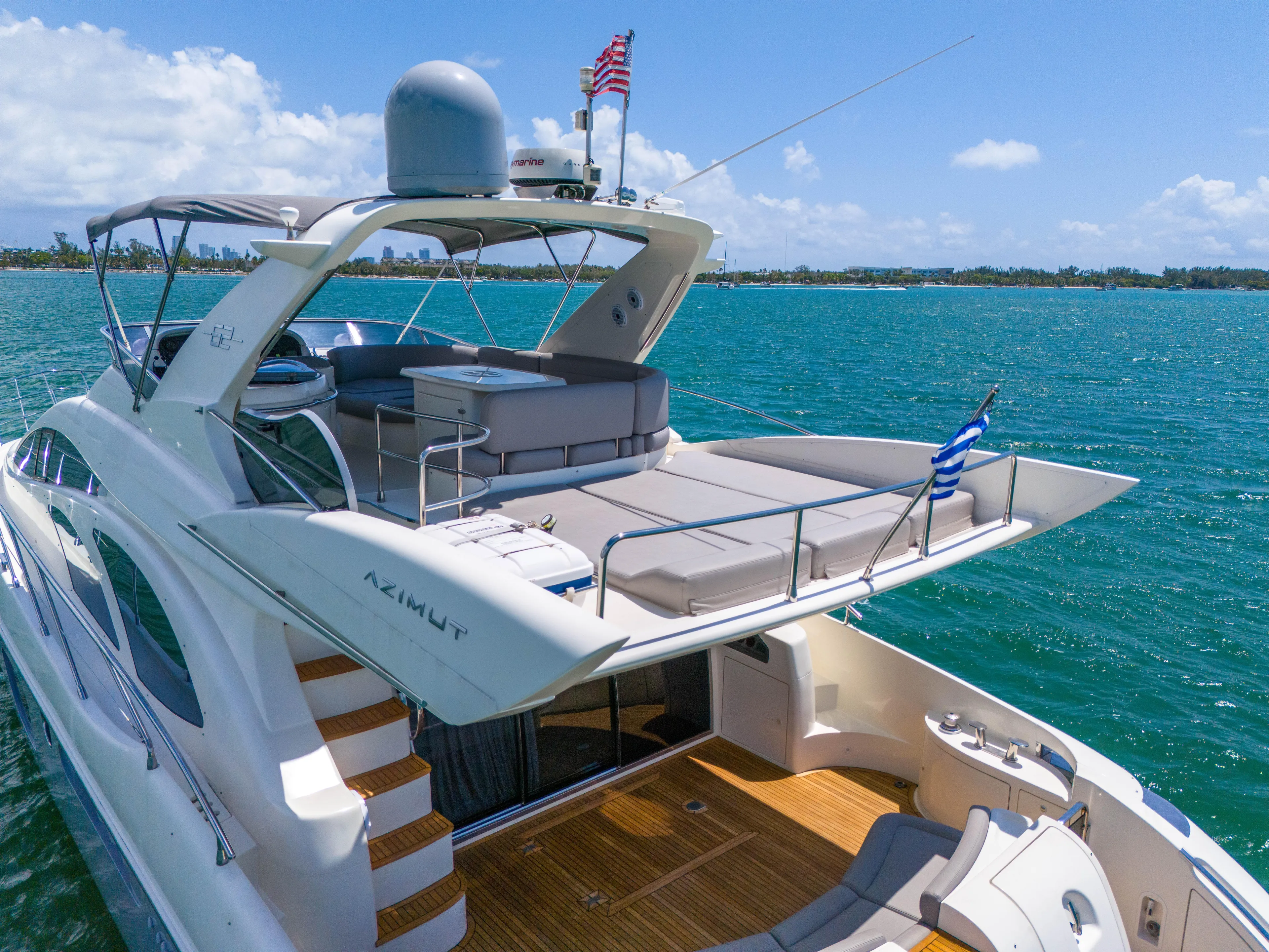 Bellami Too Yacht Photos Pics Luxurious 2008 Azimut 62E yacht cruising on clear blue waters under a sunny sky.