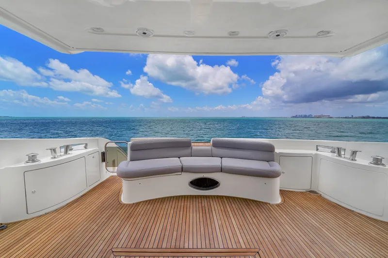 Bellami Too Yacht Photos Pics 2008 Azimut 62E yacht deck with ocean view, featuring curved seating and wooden flooring.