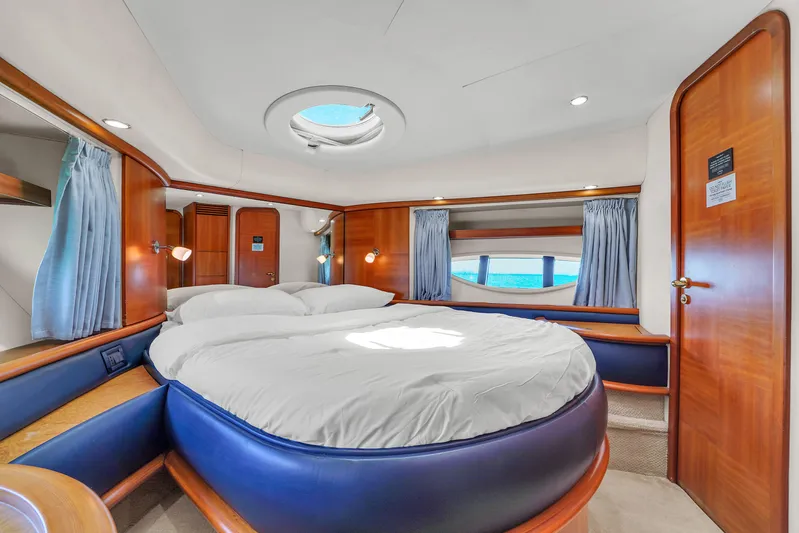 Bellami Too Yacht Photos Pics Luxurious 2008 Azimut 62E yacht bedroom with round bed, wood accents, and ocean view.
