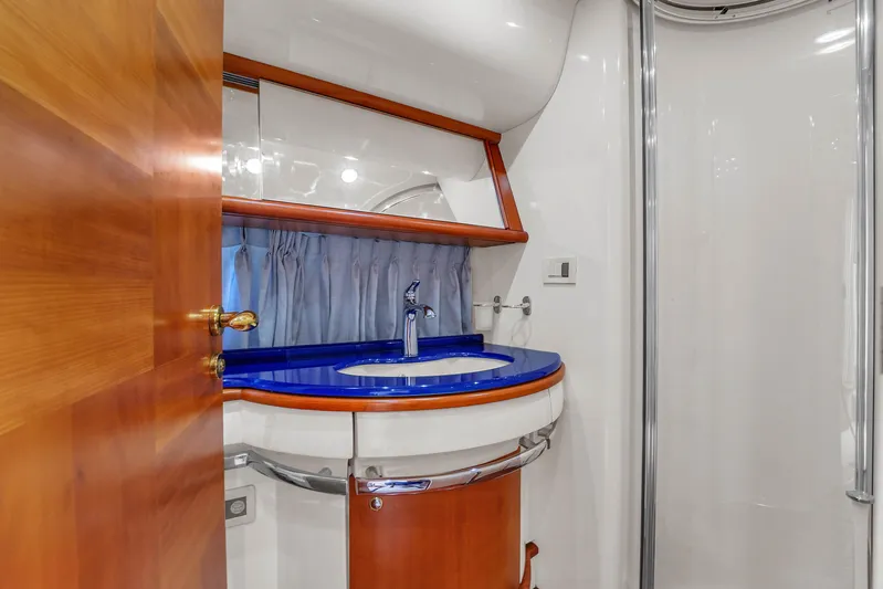 Bellami Too Yacht Photos Pics Bathroom interior of 2008 Azimut 62E yacht with blue countertop and wooden accents.
