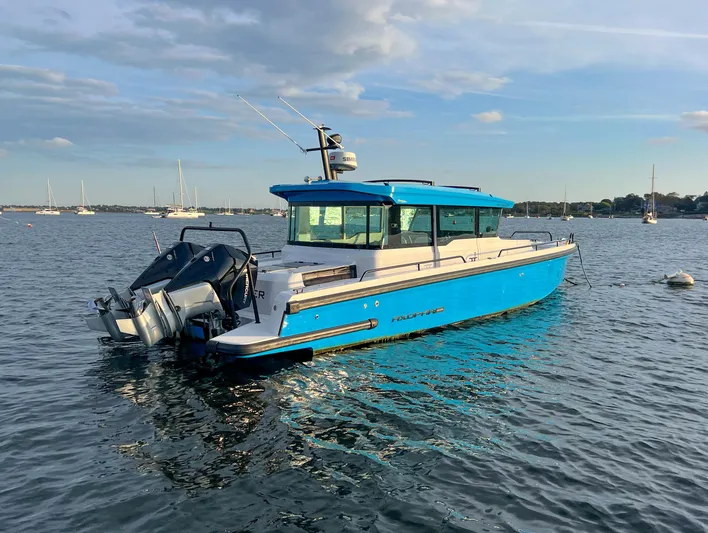 Tiny Dancer Yacht Photos Pics 2020 Axopar 37 XC boat in blue, anchored on calm water under a clear sky.