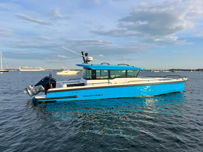Tiny Dancer Yacht Photos Pics 2020 Axopar 37 XC boat on calm water, blue and white design, side view.