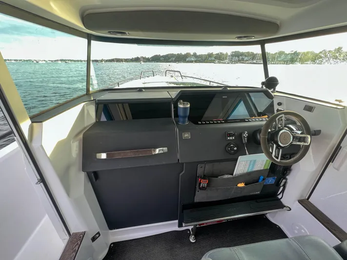 Tiny Dancer Yacht Photos Pics 2020 Axopar 37 XC helm with steering wheel, dashboard, and water view.