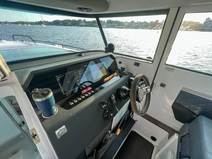 Tiny Dancer Yacht Photos Pics 2020 Axopar 37 XC helm with modern controls, overlooking a scenic water view.