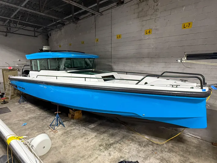 Tiny Dancer Yacht Photos Pics 2020 Axopar 37 XC boat in a garage, vibrant blue hull, sleek design.
