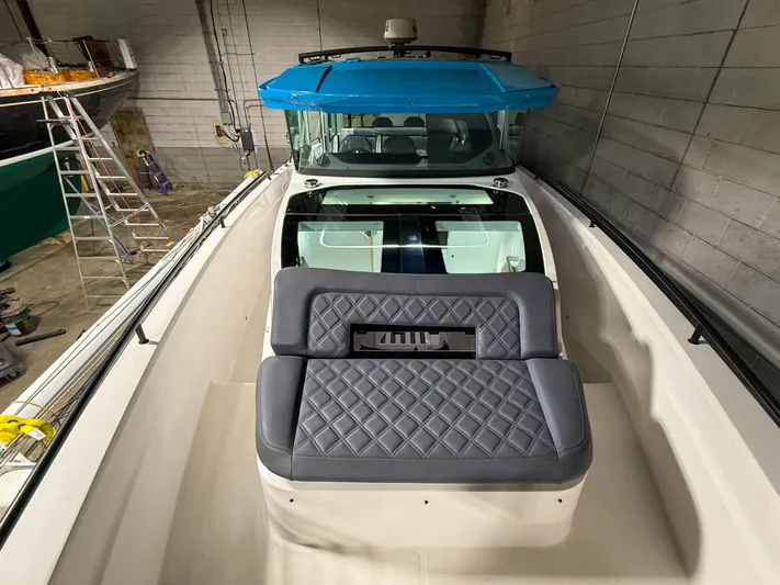 Tiny Dancer Yacht Photos Pics 2020 Axopar 37 XC boat with blue roof and quilted seating in a storage facility.