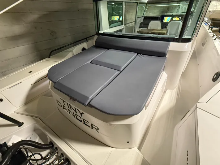Tiny Dancer Yacht Photos Pics 2020 Axopar 37 XC boat with cushioned seating and sleek design in a showroom.