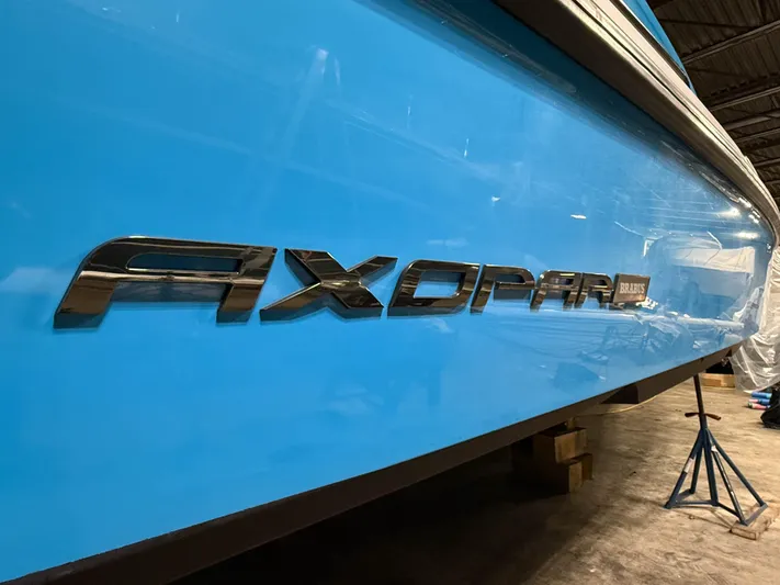 Tiny Dancer Yacht Photos Pics Blue 2020 Axopar 37 XC boat with logo in a storage facility.