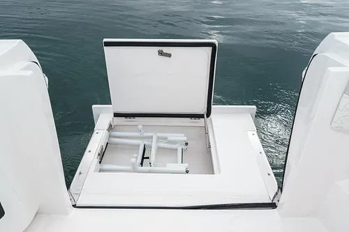 R&r 5 Yacht Photos Pics 2022 Intrepid 477 Evolution boat with open hatch, revealing ladder, on calm water.