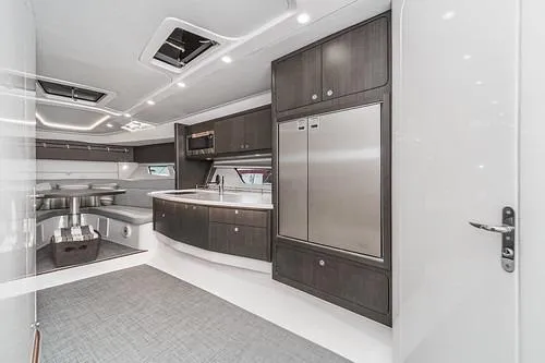 R&r 5 Yacht Photos Pics Luxurious interior of 2022 Intrepid 477 Evolution yacht with modern kitchen and seating area.